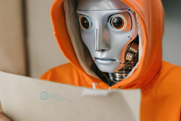 Robot wearing an orange hoodie holding a piece of paper with the words Data Protection education is transparent text